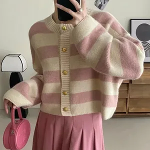 Close-up detail of a pink and cream striped knitted cardigan featuring elegant gold buttons