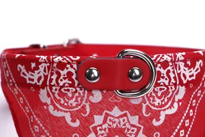 Detailed macro shot of red paisley pet bandana collar featuring metal D-ring hardware.