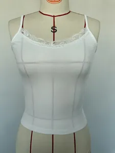 Gedetailleerde weergave van wit geribbelde camisole met fijn kanten bies bij de halslijn