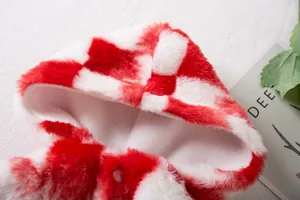 Vista detallada del suave peluche de cuadros rojos y blancos en una capucha para mascotas
