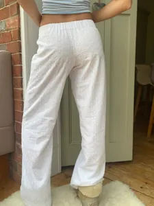 Detaillierte Rückansicht der weißen, hoch taillierten Sommerhose mit Lochstickerei und weitem Bein