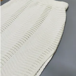 Detail shot of white knitted bodycon skirt featuring intricate pointelle wave textures