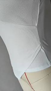 Macro detail of white ribbed fabric and cross-hem stitching on a women's tank top.