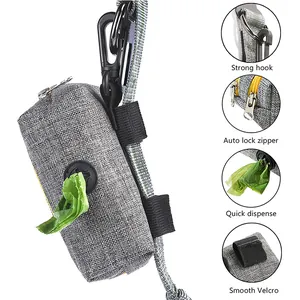 Detail view of a grey fabric dog poop bag dispenser with hook and velcro for leash.