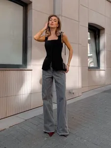 Model showcasing a chic black square neck sleeveless corset top on a city street