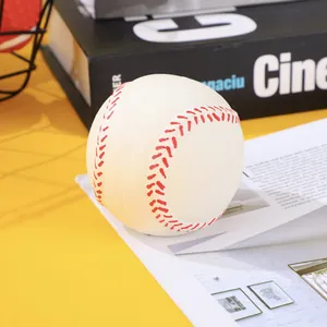 Macro detail of a white latex baseball squeaky ball dog toy with red stitching patterns