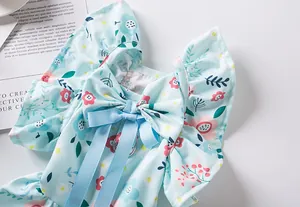 Close-up detail of light blue floral dog dress featuring a ribbon bow and metal D-ring