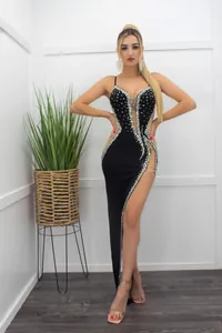 Detail shot of a sexy black evening dress featuring rhinestones and sheer mesh panels.
