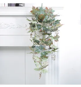 Close-up detail of artificial autumn maple leaf vine with berries for festive decor