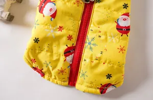 Detailed view of the red zipper and festive Santa pattern on a yellow thickened dog vest