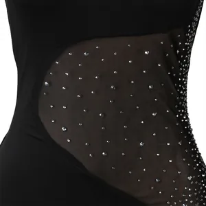 Primo piano di strass scintillanti su tessuto a rete nera di un body da discoteca.