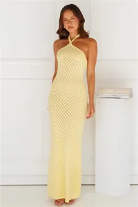Full length view of a light yellow halter neck maxi dress featuring elegant crochet texture