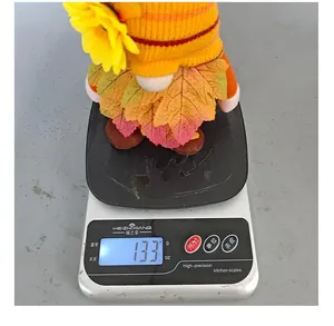 Erntedank-Zwerg mit Sonnenblume und Ahornblättern wiegt 133 Gramm auf einer Waage