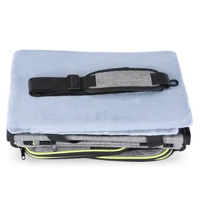 Detail view of a folded grey expandable pet carrier with a soft blue fleece mat