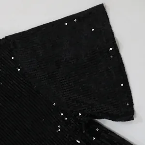 Macro detail of the black sparkling sequins on the short-sleeved fashion dress fabric