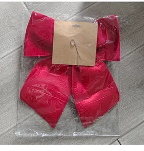 High-quality large red velvet Christmas bow presented in transparent retail packaging