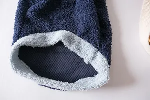 Vue macro du tissu sherpa bleu marine doux et de la doublure en polaire bleu clair.