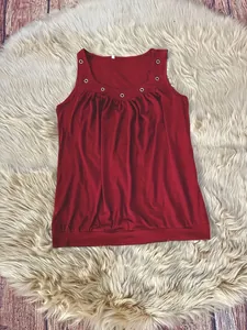 Detailansicht eines dunkelroten Damen-Tops mit Rundhalsausschnitt und Metallösen
