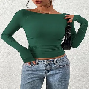 Dettaglio di un crop top verde a maniche lunghe con scollo a barca in maglia a coste.