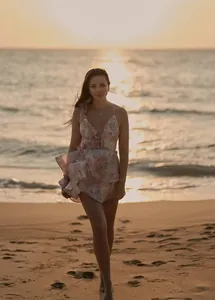 French style floral print mini dress with ruffled layers and cinched waist on beach