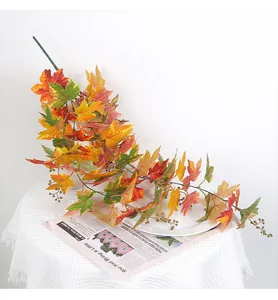 Detail shot of autumn artificial maple leaf vine with colorful leaves and berries