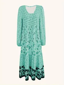 Detailed front view of a mint green tiered maxi dress with floral patterns and round neck