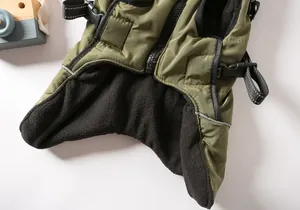 Detailed close-up of green dog winter vest showing thick warm fleece lining and zipper