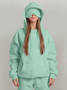 Mint green oversized streetwear hoodie featuring a unique built-in eye mask and pocket.