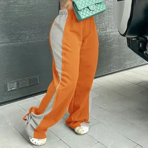 Detail einer zweifarbigen, weit geschnittenen Jogginghose für Damen in Orange.