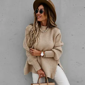Λεπτομέρεια ενός μπεζ oversized πλεκτού πουλόβερ σε ένα μοντέλο.