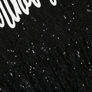 Macro view of black shimmering sequin fabric texture with white printed text details