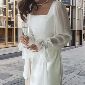 Elegant close-up of a white square neck evening dress with ruffled mesh puff sleeves