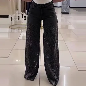 Detailed view of high-waist wide-leg jeans with elegant floral lace patchwork