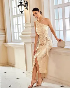 Elegant one-shoulder gold sequin cocktail dress worn by model in a luxury interior.