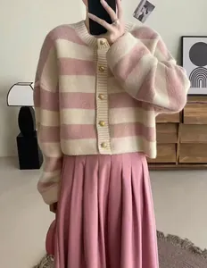 Close-up detail of a soft pink and cream striped knit cardigan with gold buttons