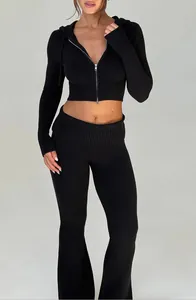 Dettaglio di una felpa con cappuccio corta nera e pantaloni svasati coordinati.