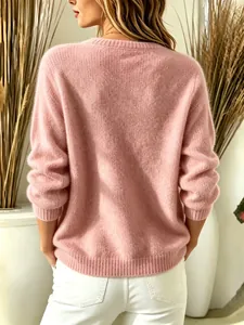 Back view of a soft pink long-sleeve knit sweater in a minimalist indoor setting.
