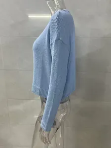 Detail side view of a light blue knitted long sleeve sweater featuring textured fabric