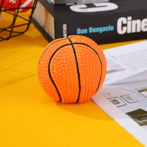 Detailed close-up of a textured orange latex basketball dog toy on a yellow surface