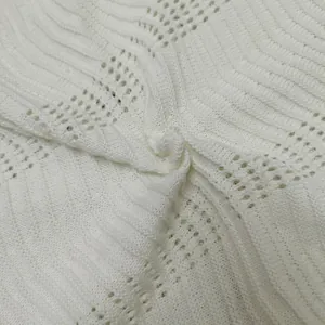 Macro detail of white wavy crochet knit fabric texture for stylish summer clothing