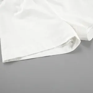 Macro detail of white cotton linen shorts hem showing quality stitching and texture