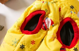 Detailed macro view showing red armhole trim and Santa pattern on yellow dog winter vest