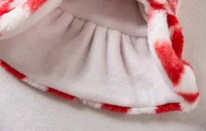Primer plano del forro suave y la tela peluda roja y blanca del vestido para mascotas