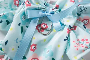 Close-up detail of blue floral pet dress harness with ribbon bow and metal D-ring