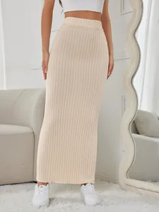 Close-up detail of a beige high-waisted ribbed knit maxi skirt featuring a bodycon fit