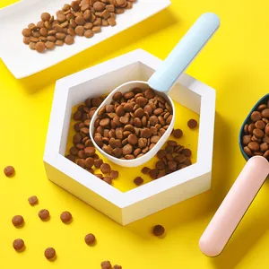 Pala ergonómica para comida de perros y gatos sobre fondo amarillo