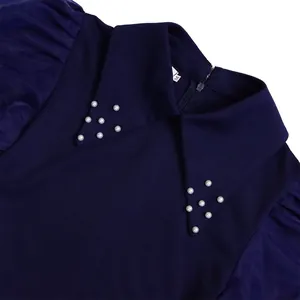 Detailed view of navy blue dress collar with pearl beads and sheer mesh puff sleeves