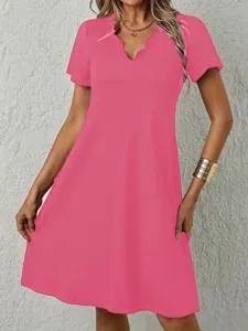 Dettaglio ravvicinato di un abito estivo rosa a maniche corte con scollo a V smerlato da donna.