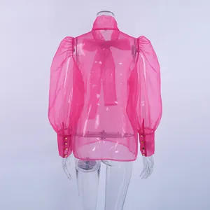 Vista trasera de blusa de malla rosa transparente con mangas abullonadas y un lazo