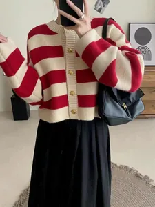 Close-up of a red and beige striped knit cardigan featuring elegant gold buttons for winter.